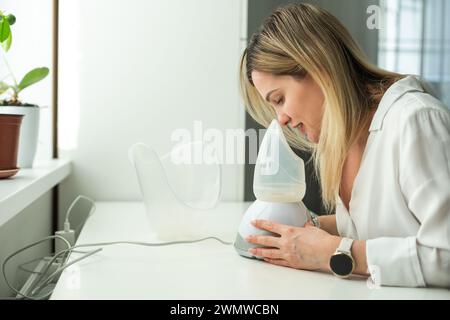 Frau hat eine schlimme Erkältung und versucht eine Therapie mit einem Inhalator Stockfoto