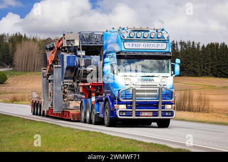 Der maßgeschneiderte Scania 164 Lkw-Auflieger PHP Group Oy transportiert Brechmaschinen als Übergröße entlang der Autobahn 52. Salo, Finnland. Mai 2022. Stockfoto