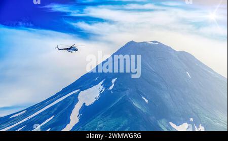 Der Hubschrauber fliegt über den Vulkan Iljinski und den Kurilen-See bei Sonnenlicht Stockfoto