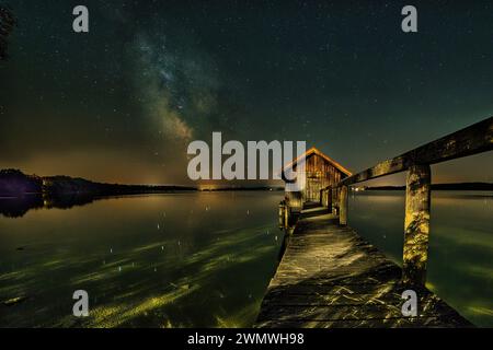 A beautiful milky way sky above a wooden hut over Lake Ammersee, Bavaria, Germany Stockfoto