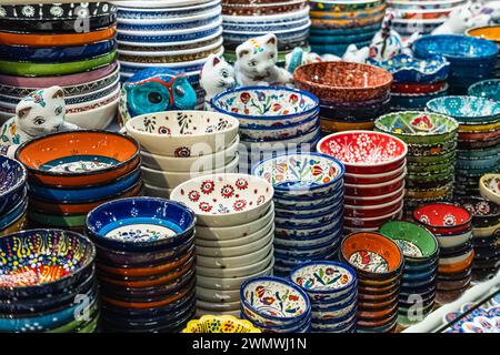 Auswahl an bunt handbemalten Tellern zum Verkauf auf einem Markt. Dekorative Keramikplatten auf einem Regal eines Geschäfts. Sammlung von bunten Keramiktöpfen Stockfoto