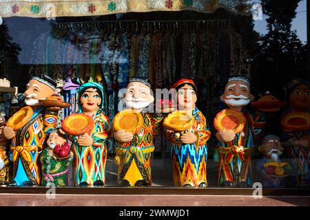 Keramikfiguren usbekischer alter Männer und Frauen in traditioneller Kleidung mit rundem Brot Lepeshka im Souvenirladen in Samarkand, Usbekistan Stockfoto