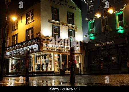 Killarney High Street in der Nacht im Winter nach dem Regen im County Kerry Irland. Nächtlicher Blick auf die kleine Stadt Stockfoto