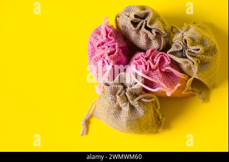 Lavendelblüte in einem Leinensack auf gelbem Hintergrund, duftender Lavendelbeutel. Stockfoto