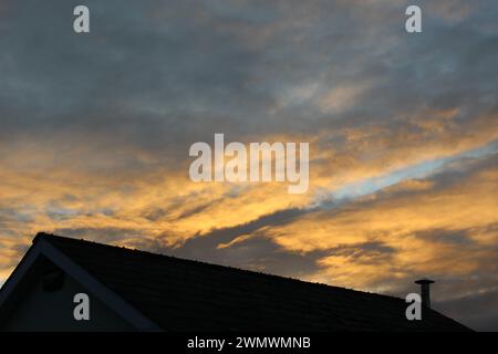 Sonnenuntergang über dunklem Dach mit Zinnschornstein im ländlichen Irland. Landschaftsposter mit Kopierraum Grafik Ressource Bruff, County Limerick Stockfoto