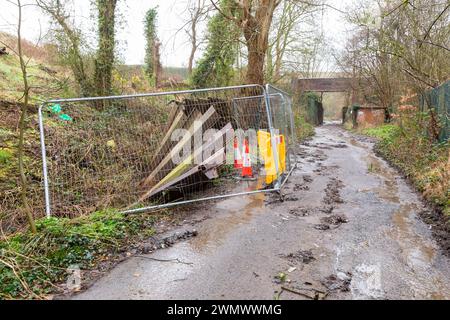 Dudley, West Midlands, Großbritannien. Februar 2024. Nach der Nachricht, dass die Besitzer des Crooked House, das letzten August niedergebrannt wurde, angewiesen wurden, den berühmten Pub in der Nähe von Dudley, West Midlands, wiederaufzubauen. Der Standort verschlechtert sich derzeit, und die zweihundert-Meter-Straße, die zum Pub-Gelände führt, ist von umgestürzten Bäumen blockiert und hat an der Seite der Straße verstreuten Müll mit Fliegenkippen. Eiserne Hochwasserbarrieren stürzen ein. Quelle: Peter Lopeman/Alamy Live News Stockfoto