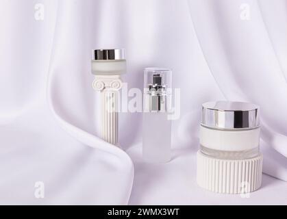 Stilvolle Kosmetikgläser aus Milchglas mit silbernem Deckel mit luxuriöser Creme und Serum für die Haut von Gesicht und Körper. Naturpflege. Schönheitskonzept Stockfoto