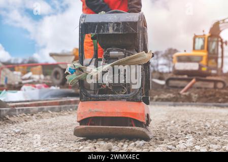 Vibrationsplattenverdichter auf kompaktem Boden und Stein auf der Baustelle Stockfoto