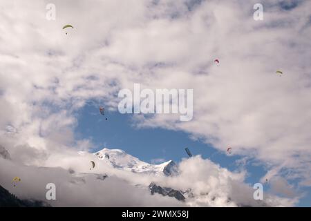 Bunte Gleitschirmflieger fliegen im Sommer über dem Gipfel des Mont Blanc (4807 m ü. M.) in den französischen Alpen, Chamonix, Haute Savoie, Frankreich Stockfoto