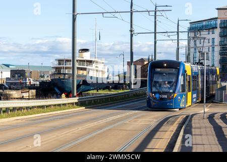 Eine Straßenbahn auf dem Ocean Drive nach Newhaven mit dem Fingal Luxury Hotel im Hintergrund, Leith, Edinburgh Stockfoto