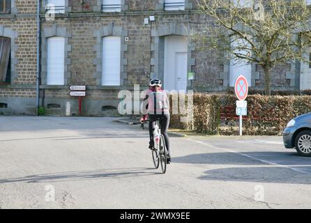 Eine junge Dame radelt durch die Straßen von Saint-Fraimbault, Normandie, Frankreich, Europa Stockfoto