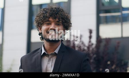 Hispanisch arabischer Geschäftsmann lächelnd glücklicher Geschäftsmann in der Stadt Porträt Erfolg städtischer Unternehmer Blick auf Kamera Lächeln in der Innenstadt männlich Stockfoto