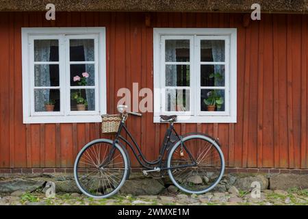 Altes Holzfenster und Fahrrad, Damenfahrrad, Bauernhaus, Dekoration, Fenster, historisches, altes, altes, verzweigtes Fenster, dekoriert, schön, antik Stockfoto