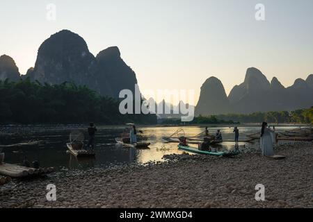 Yangshuo County, Guilin City, Guangxi, China - 23. Oktober 2023: Touristen in traditionellen chinesischen Kostümen machen Fotos entlang des Li-Flusses in der Abenddämmerung Stockfoto