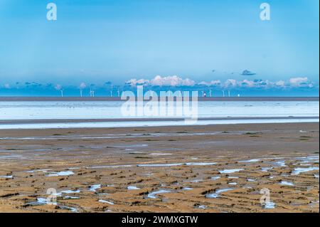 Blick über das Wattenmeer mit Windturbinen am Horizont unter einem riesigen blauen Himmel mit Wolken, Windpark im Wattenmeer, Ostfriesland, Niedersachsen Stockfoto