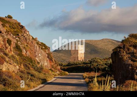 Eine Straße führt zu einem alten Turm in einer bergigen Landschaft während der goldenen Stunde, Wohnturm, Hotel, Mani Halbinsel, Peloponnes, Griechenland Stockfoto