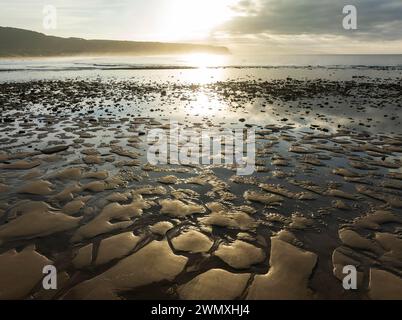 Sonnenaufgang bei Ebbe am Ufer des Atlantischen Ozeans in der Nähe von Cape Trafalgar. Luftaufnahme. Drohnenaufnahme. Costa de la Luz, Provinz Cadiz, Andalusien Stockfoto