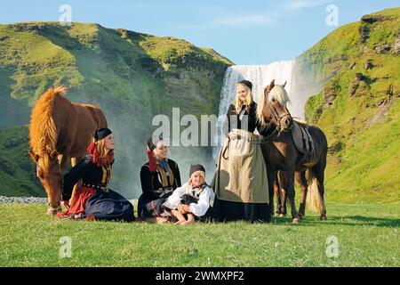 Historische Szene mit isländischen Pferden vor dem Skogafoss-Wasserfall. Island Stockfoto