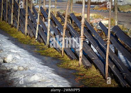 Der alte Zaun entlang der Landstraße. Country Timber Fence. Alter Holzzaun Stockfoto