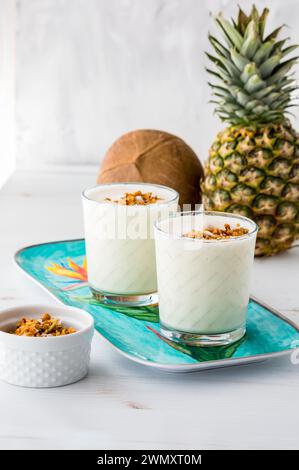 Erfrischende Ananas-Kokos-Smoothies, bereit zum Trinken. Stockfoto