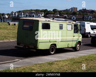 Ein 1977er-Wohnmobil „Mercedes Benz 608D“ in Limonengrün mit markantem Rauchschacht, der durch das Dach des Fahrzeugs ragt. Stockfoto