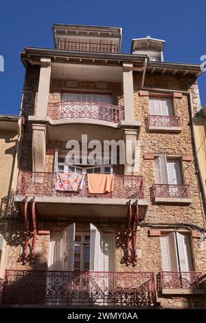 Frankreich, Jura, Saint Claude, Apartmenthaus mit roten schmiedeeisernen Balkongeländern Stockfoto