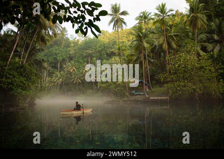 Ein Mann, der auf einem Boot am Paisu Pok Lake in Luk Panenteng, Banggai, Sulawesi, Indonesien fährt. Stockfoto