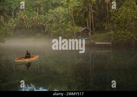 Ein Mann, der auf einem Boot am Paisu Pok Lake in Luk Panenteng, Banggai, Sulawesi, Indonesien fährt. Stockfoto