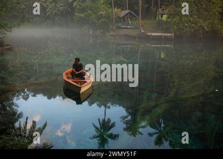 Ein Mann, der auf einem Boot am Paisu Pok Lake in Luk Panenteng, Banggai, Sulawesi, Indonesien fährt. Stockfoto