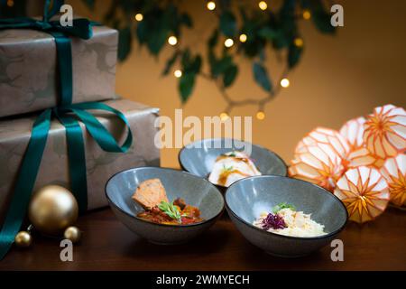 Feiern Sie stilvoll mit wunderschönen Gourmet-Kanapees auf einem festlichen Tisch, ergänzt durch geschmackvolle Dekorationen und warme Lichter. Stockfoto