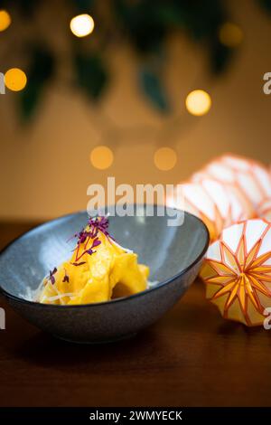 Tortellini aus Käse und Walnüssen in einer Schüssel, verziert mit einer zarten, essbaren Blumengarnitur. Stockfoto