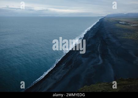 Aus der Vogelperspektive fängt die raue Schönheit der schwarzen Sandstrände Islands vor den Wellen des Nordatlantiks ein. Stockfoto