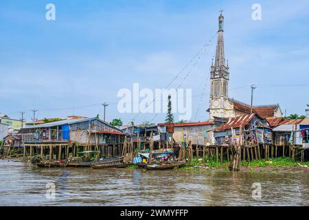 Vietnam, Mekong Delta, Cai Be, die Ufer des Kanals Kinh 28, der in den Mekong mündet, im Hintergrund die katholische Kirche Cai Be Stockfoto