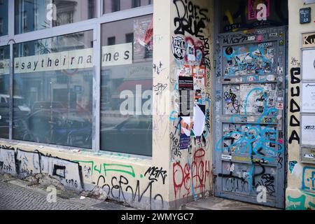 Berlin, Deutschland. Februar 2024. "Sag ihre Namen" - was sich eigentlich auf die Opfer des rassistisch motivierten Angriffs in Hanau im Jahr 2020 bezieht - steht an einem Fenster, während die Haustür eines Hauses in Kreuzberg mit Aufklebern und Graffiti bedeckt ist. Die ehemalige Terroristin der Roten Armee (RAF) Daniela Klette wurde am Montag in Berlin-Kreuzberg verhaftet. Annette Riedl/dpa/Alamy Live News Stockfoto