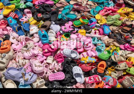 Ein riesiger Stapel farbenfroher Kindersandalen zum Verkauf im Darajani Souk in Stone Town, Sansibar, Tansania Stockfoto