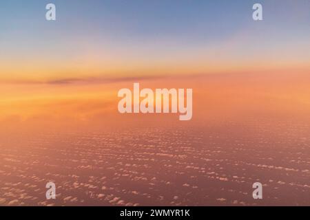 Abendliche Wolkenlandschaft in der Nähe der Kanarischen Insel Lanzarote, Spanien von einem vorbeifahrenden Flugzeug aus in Richtung Sonnenuntergang. Stockfoto