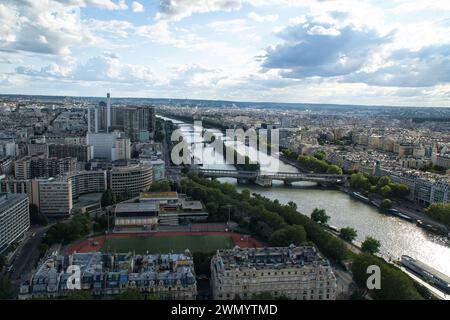 Ein Panoramablick auf die Skyline von Paris, einschließlich der von Booten gesäumten seine, einem goldenen Untergang des invalidenpalastes und anderer historischer Denkmäler, Stockfoto