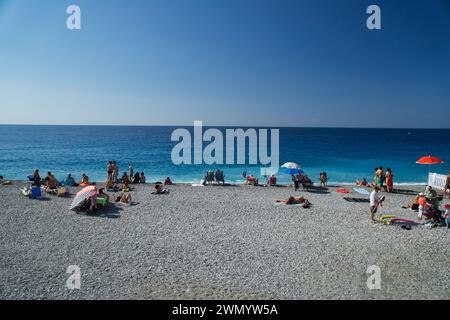 Cannes, Frankreich - August 3,2021: An einem warmen, sonnigen Tag entspannen sich die Menschenmassen am berühmten Strand Plage des Rochers in Cannes in Frankreich. Stockfoto