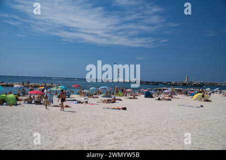 Cannes, Frankreich - August 3,2021: An einem warmen, sonnigen Tag entspannen sich die Menschenmassen am berühmten Strand Plage des Rochers in Cannes in Frankreich. Stockfoto