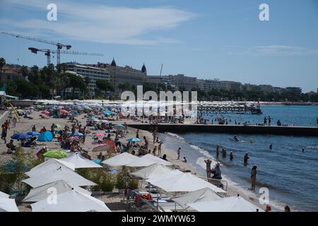 Cannes, Frankreich - August 3,2021: An einem warmen, sonnigen Tag entspannen sich die Menschenmassen am berühmten Strand Plage des Rochers in Cannes in Frankreich. Stockfoto