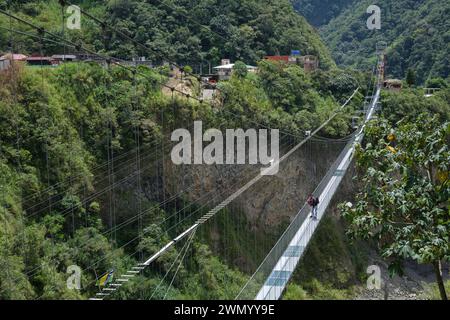 Die Menschen laufen auf einer langen Seilbrücke über eine tiefe Schlucht in einem Abenteuerpark in Ecuador Stockfoto