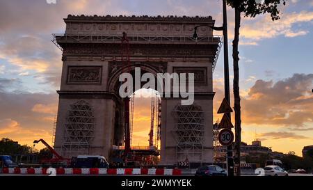 Paris, Frankreich - 31. Juli 2021: Wunderschöner Sonnenuntergang und farbenfroher Himmel über dem Triumphbogen, der gerade auf den Champs-Elysées in Paris renoviert wird Stockfoto