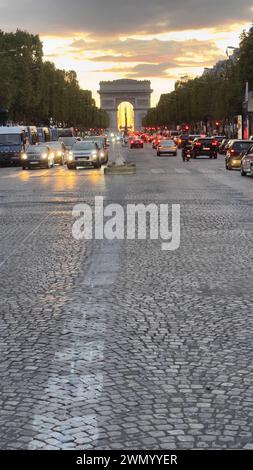 Paris, Frankreich - 31. Juli 2021: Wunderschöner Sonnenuntergang und farbenfroher Himmel über dem Triumphbogen, der gerade auf den Champs-Elysées in Paris renoviert wird Stockfoto