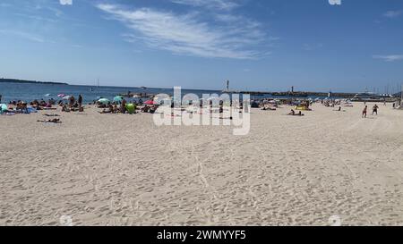 Cannes, Frankreich - August 3,2021: An einem warmen sonnigen Tag entspannen sich die Menschenmassen am berühmten Strand Plage des Rochers in Cannes. Stockfoto