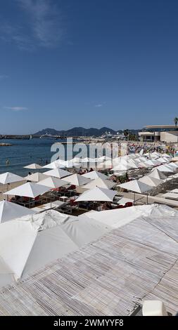 Cannes, Frankreich - August 3,2021: An einem warmen sonnigen Tag entspannen sich die Menschenmassen am berühmten Strand Plage des Rochers in Cannes. Stockfoto