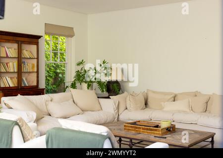 Ein gemütliches Wohnzimmer verfügt über ein weiches beigefarbenes Sofa und einen hölzernen Couchtisch Stockfoto