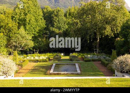 Ruhiger Garten mit Brunnen und Grün, der einen friedlichen Park nachahmt. Stockfoto