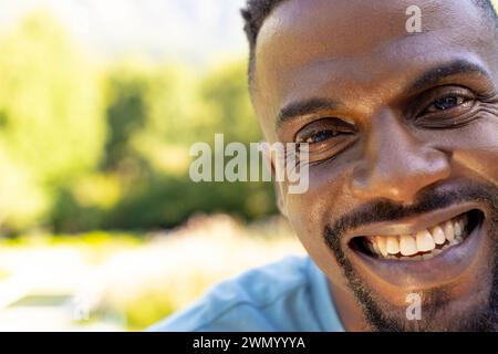 Der afroamerikanische Mann lächelt breit und zeigt einen warmen Ausdruck zu Hause mit Kopierraum Stockfoto