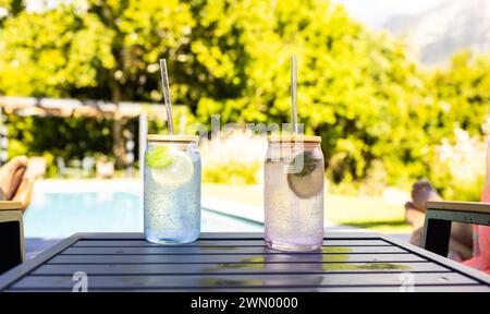 Zwei Gläser mit erfrischenden Getränken und Strohhalmen stehen auf einem Tisch im Freien Stockfoto