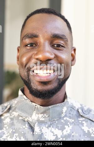 Ein afroamerikanischer Soldat lächelt warm und trägt eine Militäruniform Stockfoto